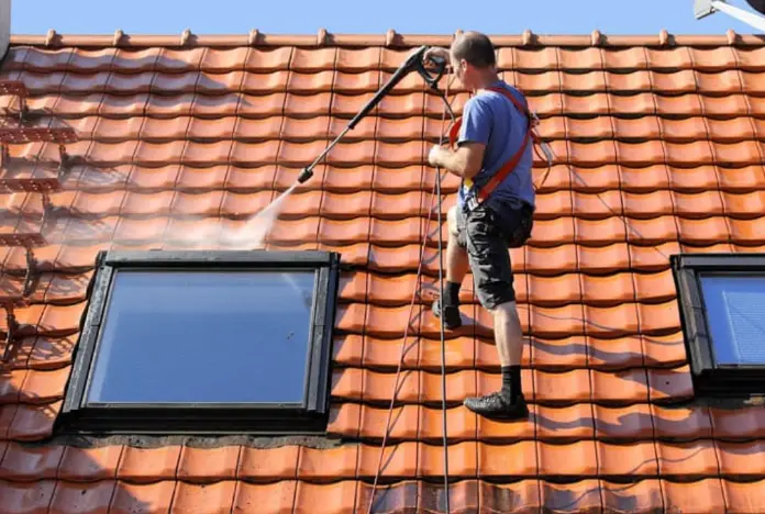 Démoussage de toiture avec vue sur les toits du centre historique de Colmar